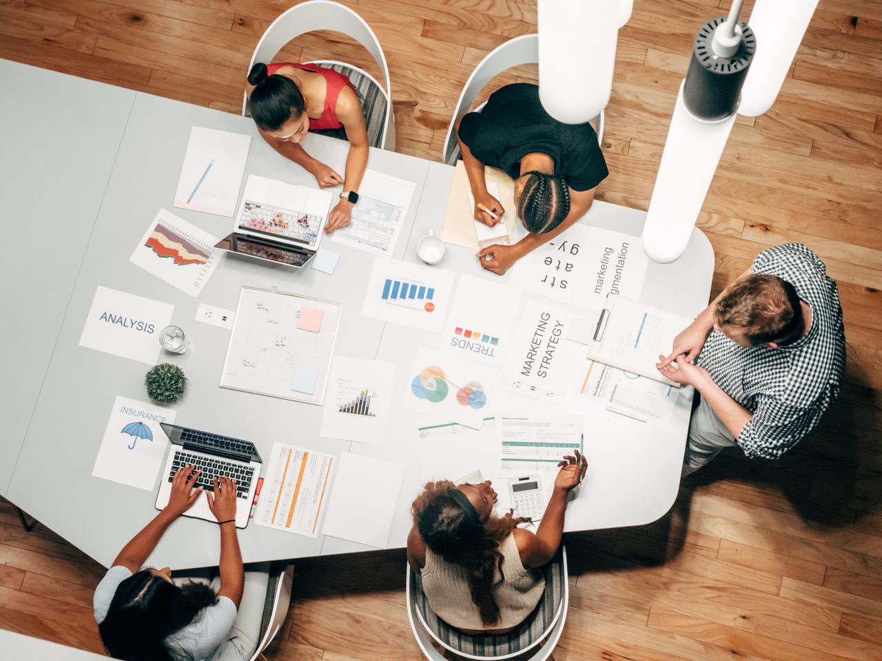 why-choose-us Diverse team collaborating on marketing strategy in a modern office setting.